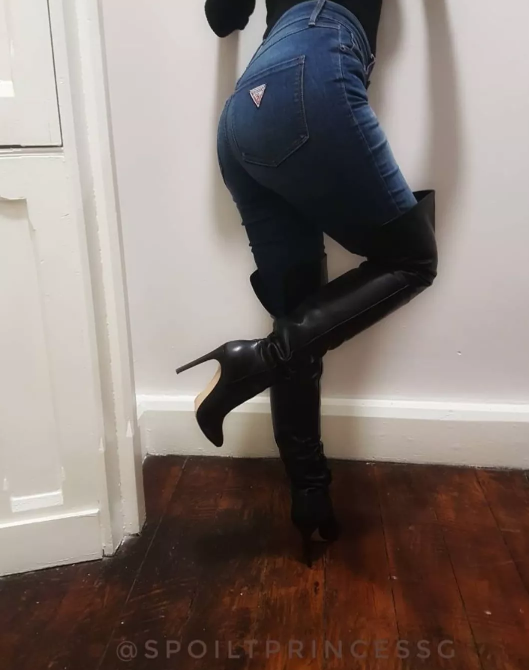 Black leather boots with blue jeans.